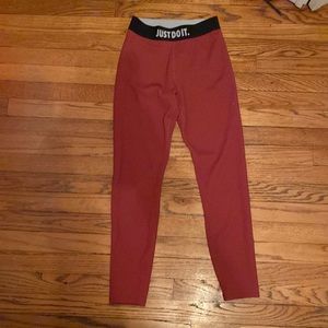 Reddish Nike leggings with black waistband that says just do it in all caps